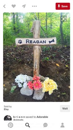 a wooden cross with flowers on the ground