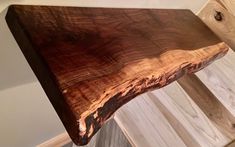 a piece of wood sitting on top of a wooden shelf next to a wall mounted clock