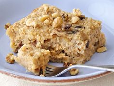 a blue plate topped with oatmeal and nuts next to a silver fork