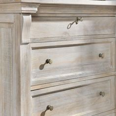 a white dresser with drawers and handles on it