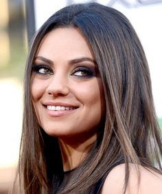 a woman with long hair smiling at the camera