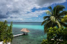 the water is crystal blue and clear with a hut on it's dock in the middle