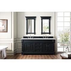 a bathroom with two sinks, mirrors and a toilet in the background on a hard wood floor