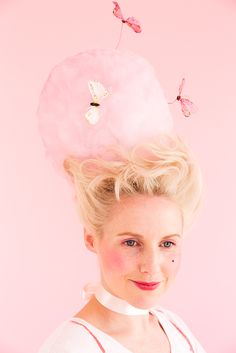 a woman wearing a pink hat with butterflies on it's top and hair in the shape of a doughnut