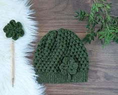 a crocheted green hat and matching pair of knitting needles