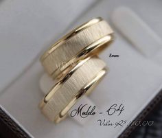 two yellow gold wedding rings in a box with the words made to be engraved on them