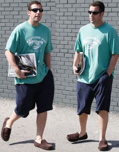 two men in green shirts and blue shorts are walking down the street with their shoes on