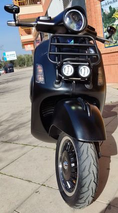 a black scooter parked in front of a building