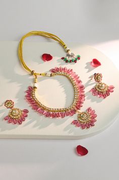 Elevate your traditional attire with this exquisite necklace set. The intricately crafted necklace features Kundan stones, beautifully complemented by stunning pink tourmaline stones, adding a touch of elegance and charm. Complete your look with the matching drop earrings for a timeless and sophisticated ensemble that's perfect for any occasion. Finish: 22KT Gold Plating Material: Silver, Copper Alloy, Kundan & Natural Stones Color: Pink Size: Free Size, Adjustable Closure Type: Draw String Box