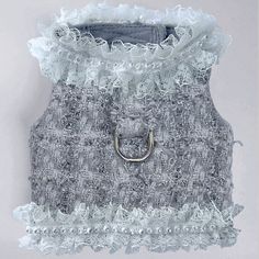 a gray and white dress with ruffles on the bottom, an open ring in the middle