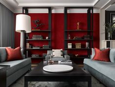 a living room with red walls and grey couches