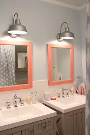 two sinks in a bathroom with pink mirrors and lights above them on the wall next to each other