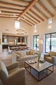 a living room filled with furniture and a chandelier hanging over the top of it