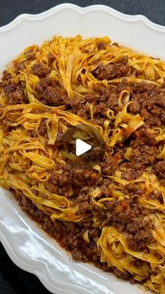 a white plate topped with spaghetti and meat