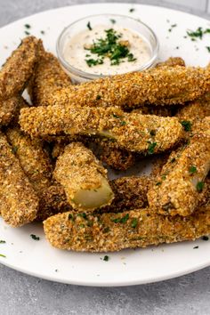 some fried food on a white plate with dipping sauce