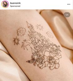 a tattoo on the leg of a woman with flowers and a castle in the background