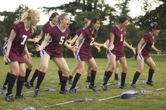 a group of girls soccer players standing next to each other on top of a field