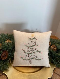 a christmas tree pillow sitting on top of a gold platter