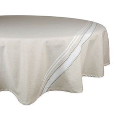 a round table with a white cloth on the top and silver trimming around it