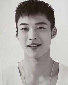 a young man wearing a white shirt and necklace