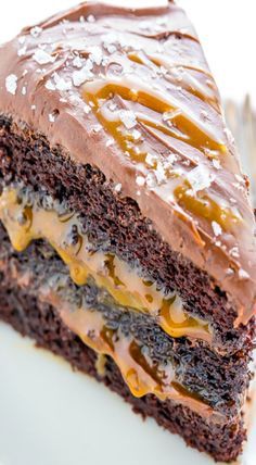 a piece of chocolate cake with caramel drizzle and frosting on top