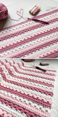 crocheted pink and white blanket laying on top of a table next to yarn