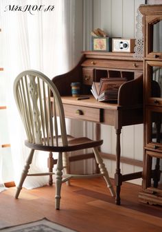 a desk with a chair next to it and a book on top of the desk