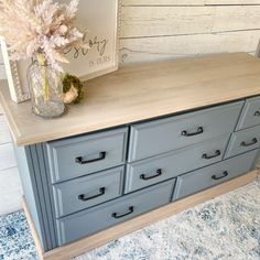 a dresser with drawers and a vase on top