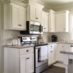 a kitchen with white cabinets and granite counter tops is pictured in this image from the front view