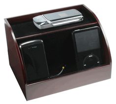 an electronic device is sitting on top of a wooden stand with two speakers and a remote control