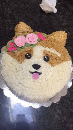 there is a cake made to look like a dog with flowers on it's head