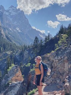 a woman standing on top of a rocky mountain