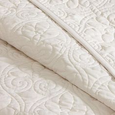 the white quilted bedding is folded up