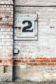 an old brick building with a number two sign on the front and back wall,