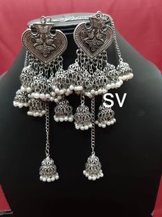 Listed as a must-have earring, jhumkis will always be a woman's favorite accessory! Our Leaf Silver Oxidised Jhumkis dangling with many mini jhumkis along are one you would opt for when you want the simple yet trendy look, pair these up with your straight kurtas or your soft mulmul sarees, these will leave you feeling pretty all day long! Oxidised Jewellery Earrings Long, Silver Temple Jewelry Chandelier Earrings With Latkans, Bohemian Silver Jhumkas With Latkans, Silver Chandelier Earrings With Dangling Beads For Festivals, Bohemian Oxidized Danglers For Navratri, Bohemian Oxidized Finish Danglers For Navratri, Bohemian Chandelier Earrings With Latkans For Diwali, Oxidized Finish Dangle Jhumkas For Navratri, Navratri Oxidized Finish Dangle Jhumkas