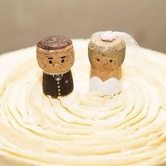 two wedding cake toppers made out of wine corks