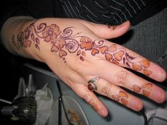 a woman's hand with a flower tattoo on it