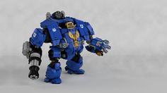 a blue and black robot standing next to a white background with the words warhammer written on it