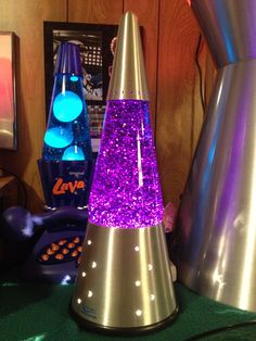 two purple and silver cone shaped objects sitting on top of a green table