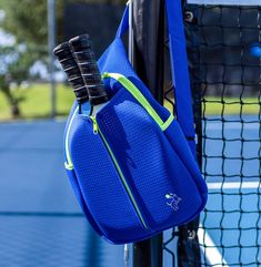 a tennis racket and bag hanging on the net