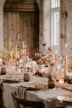 the table is set with candles and flowers