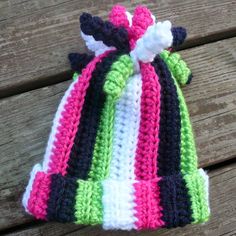 a crocheted hat sitting on top of a wooden bench