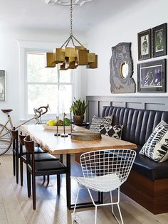 a dining room table with chairs and pictures on the wall above it, along with a bench