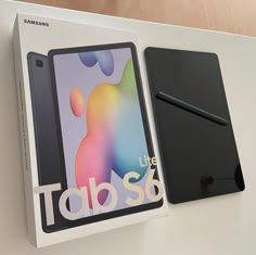 the samsung tablet is in its box next to it's packaging on a table