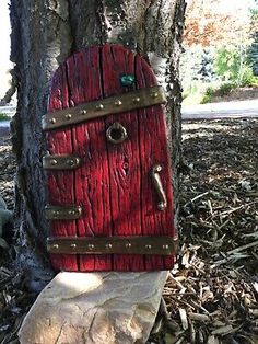 a toilet in the shape of a red door on top of a tree trunk with a key