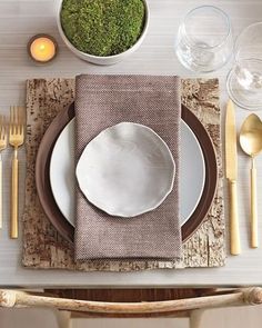 a place setting with plates, silverware and candles