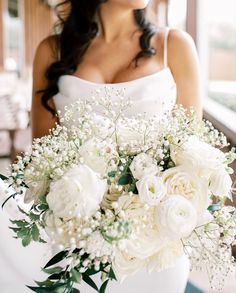 a bride holding a bouquet of white flowers