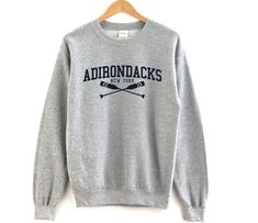 ⚑ Adirondacks New York crewneck sweatshirt ✯ The perfect crewneck sweatshirt for your favorite destination. A great casual pullover crewneck to represent your favorite city or hometown. ✯ Makes a great gift! ⌁ Unisex Size ⌁ Printed on the Gildan 18000 Sweatshirt ⌁ Loose fit ⌁ 50% Cotton; 50% Polyester (fibre content may vary for different colors) ⌁ Medium fabric (8.0 oz/yd² (271.25 g/m ⌁ Sewn in label ⌁ Runs true to size 𝑴 𝑬 𝑨 𝑺 𝑼 𝑹 𝑬 𝑴 𝑬 𝑵 𝑻 𝑺 (𝚒𝚗𝚌𝚑𝚎𝚜 𝚆𝚡𝙻) 𝚂 | 𝟸𝟶𝚡𝟸𝟽 ? New York Crewneck, Acadia Maine, Michigan Sweatshirt, New York Sweatshirt, Door County Wisconsin, Jersey Sweatshirt, Lake Placid, Traverse City, Favorite City