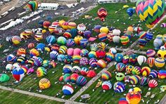 many hot air balloons are being flown in the sky at an outdoor balloon festive