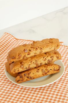 three pieces of bread sitting on top of a white and orange checkered table cloth